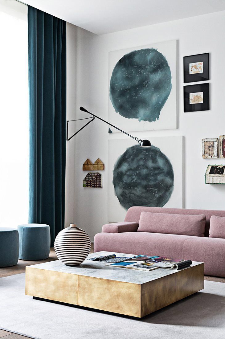 layered modern living room with wall light and blue curtains, pink sofa